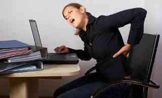 Image of typist suffering lower back pain
